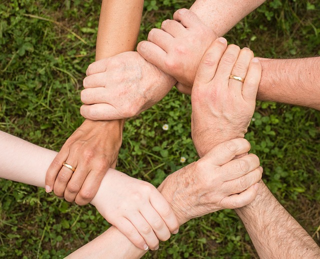 Multiple people holding hands in a ring