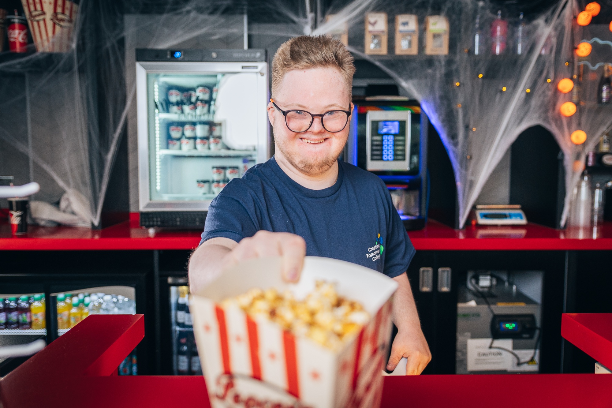 Student serving popcorn in a cinema
