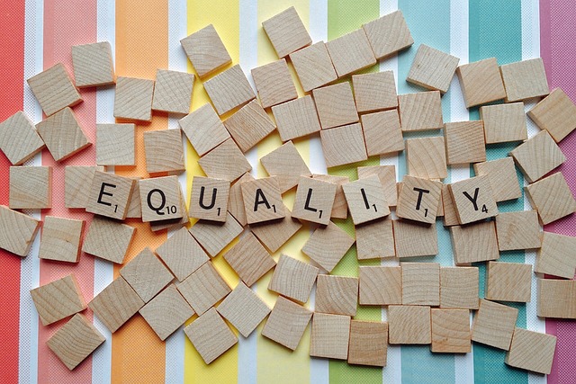 Equality spelled out on a rainbow striped background