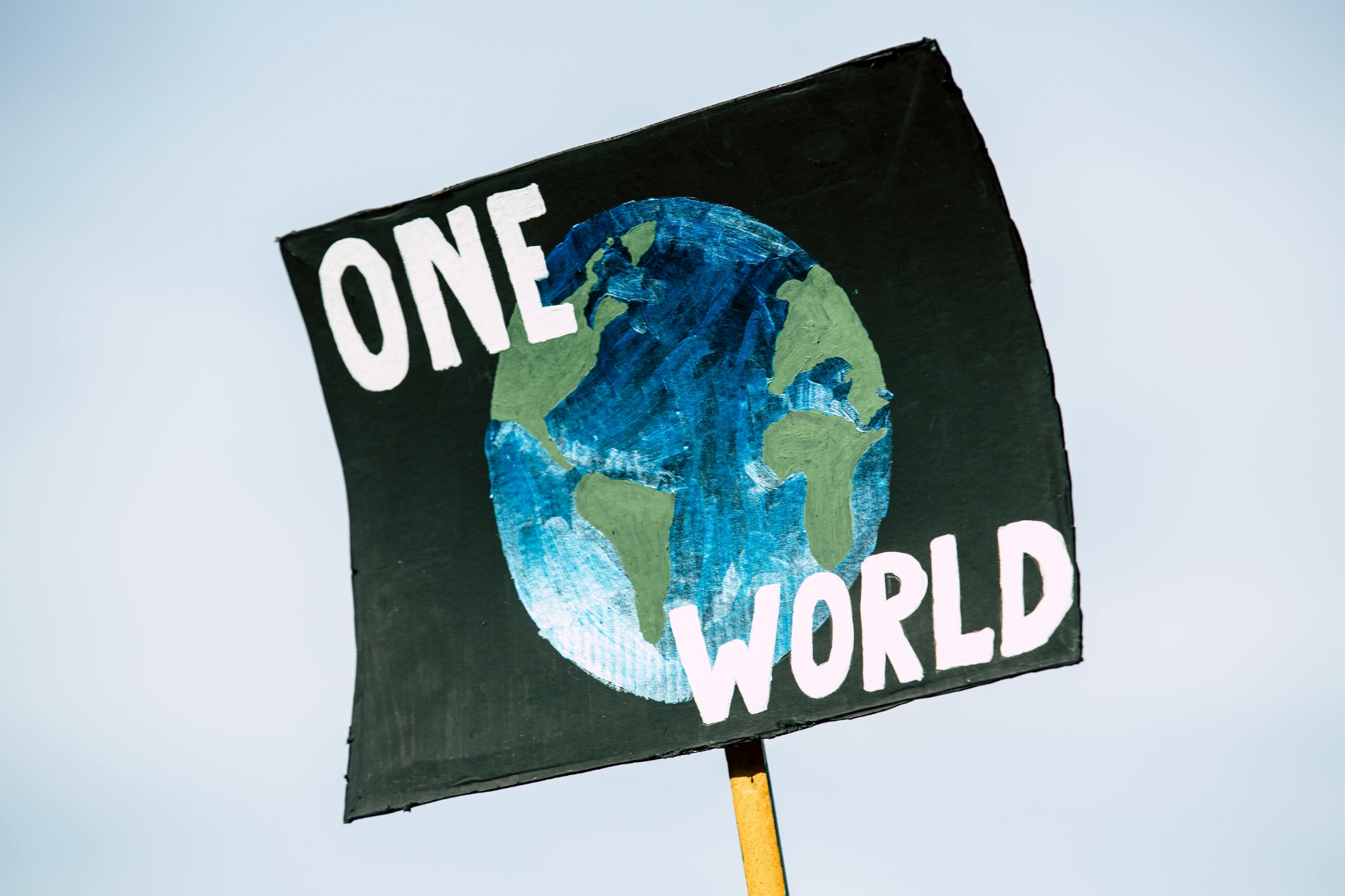Placard with One World and a globe picture