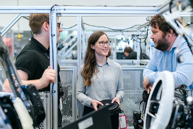 Young people talking to an adult in a manufacturing site