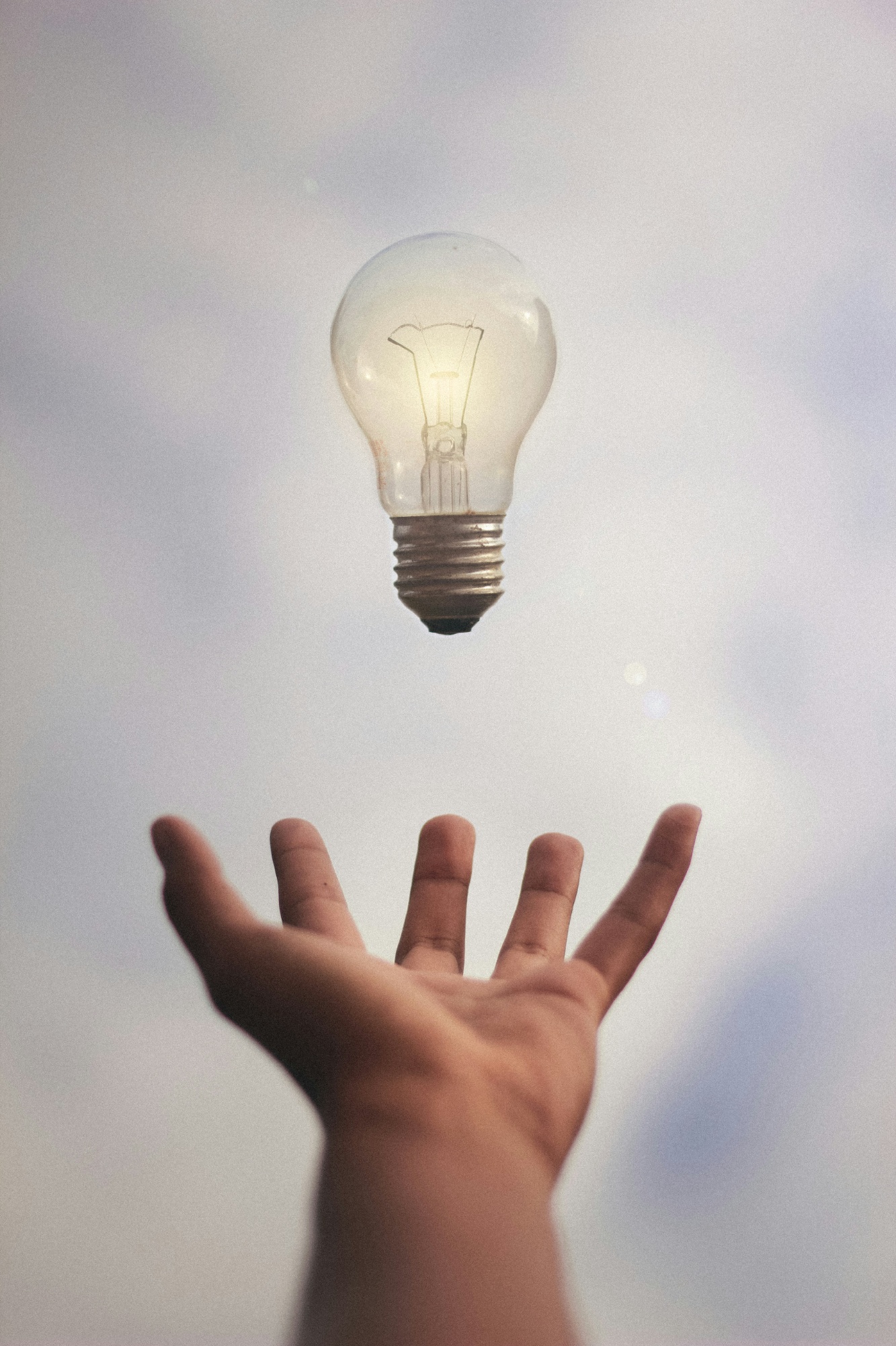 A lightbulb floating over an outstretched hand