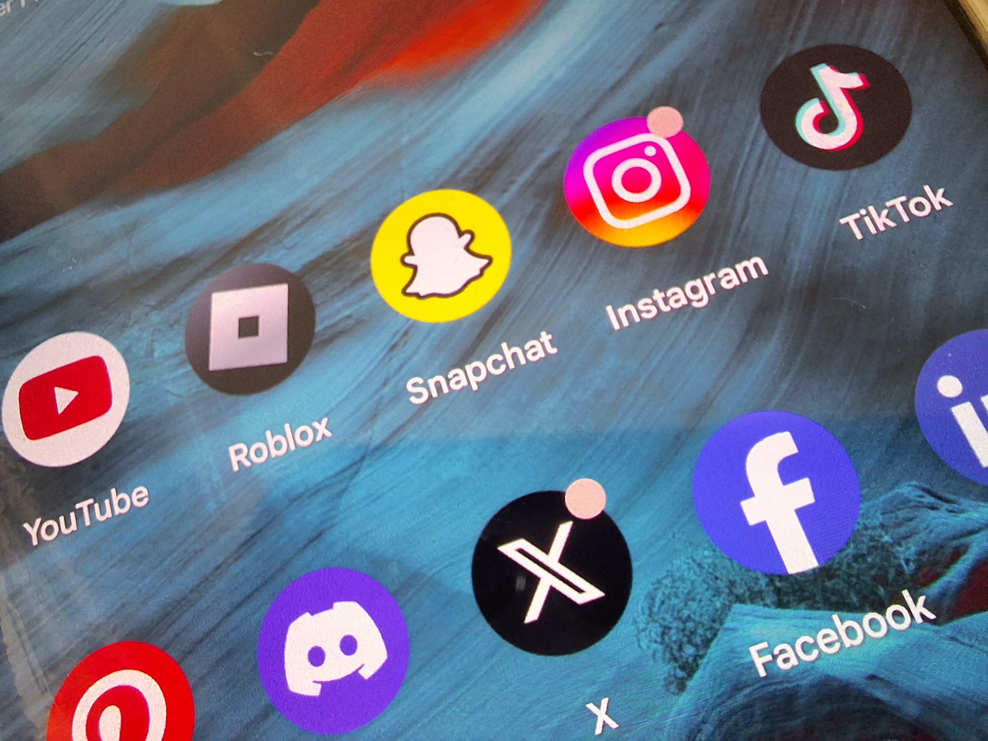 Close up imahe of phone screen with social media logos on. 