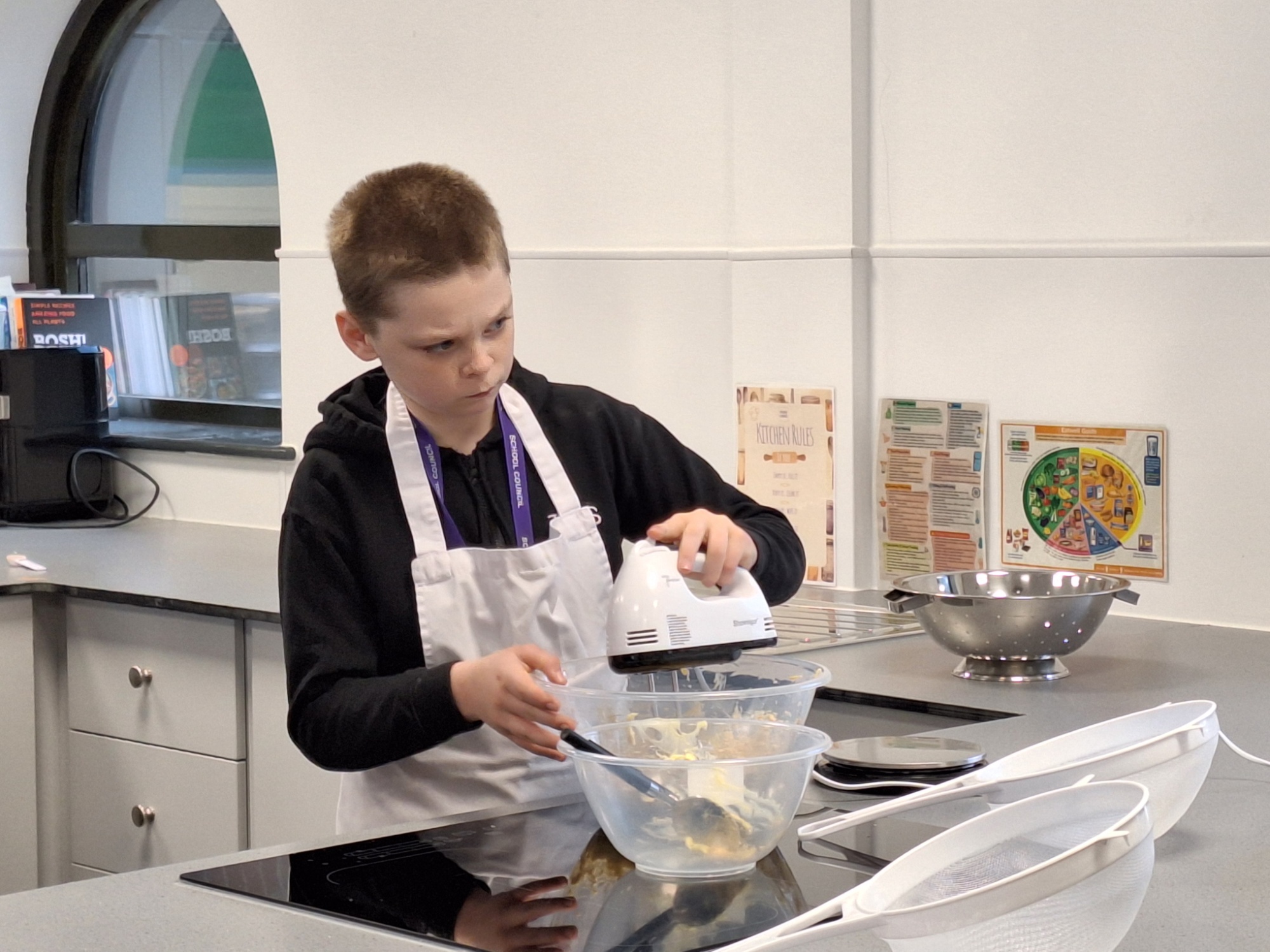 Male student baking gingerbread men in the new cooking classroom